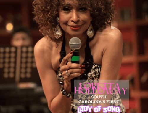 Singer performing live with a microphone in hand, wearing a pink outfit.